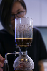 close up of barista with siphon coffee maker