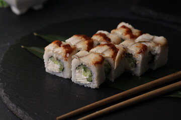 Sushi rolls on black background with salmon cheese and fish