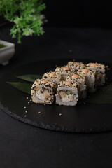 Sushi rolls on black background with salmon cheese and fish