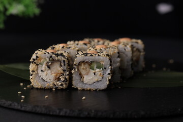 Sushi rolls on black background with salmon cheese and fish