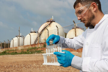 Male Biologist or specialist natural science check drain water from factory ,Water environment...