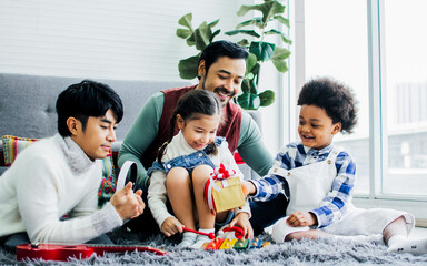 Male gay taking care adopted children who are happy diverse little Caucasian girl and African boy,...