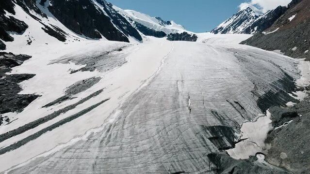 Drone flight over the melting Aktru glacier (Altai), in sunny clear weather, high mountains.