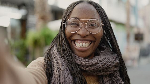 African woman taking selfie smiling at street