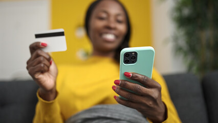 African woman shopping online with smartphone at home