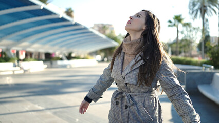 Beautiful hispanic woman standing with worried expression at park