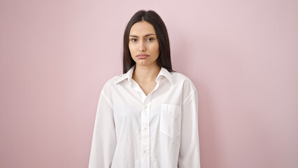 Young beautiful hispanic woman standing with relaxed expression over isolated pink background