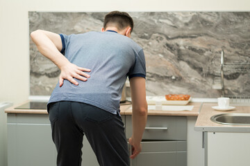 Back pain, kidney inflammation, man suffering from backache at home