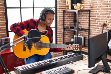 African american woman musician playing classical guitar at music studio