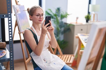 Young caucasian woman artist make photo to draw at art studio