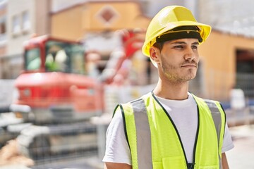 Young hispanic man architect standing with relaxed expression at park