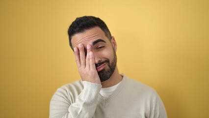 Fototapeta premium Young hispanic man standing stressed over isolated yellow background