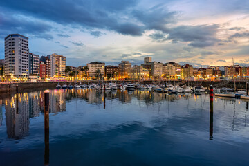Fototapeta premium Marina at sunset with promenade and sailing boats in the tourist city of Gijon, Asturias.