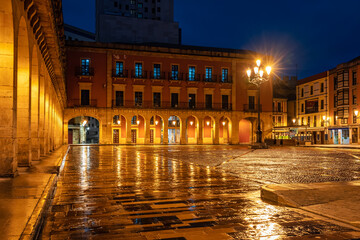 Main square of the tourist city of Gijon at night with its monumental buildings and arches in the arcades, Spain.