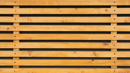 Yellow wooden bars fastened with screws background