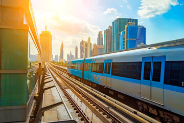 Dubai metro train on rails at background of skyscrapers. Famous outdoor subway Red Line.