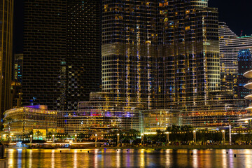 Fototapeta na wymiar Night view of many glowing windows in apartment residential tower timelapse. High rise illuminated skyscraper with lights in rooms.