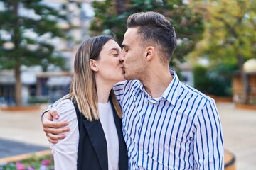 Fototapeta premium Man and woman couple hugging each other kissing at park
