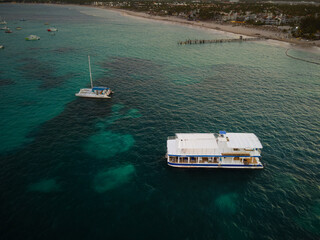 Pleasure boats in the sea. Palm forest grows on the shore, tropics. Beautiful seascape. Sea trips, fresh air, ecology, environmental protection.