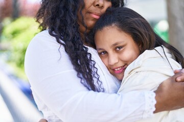 Obraz premium Mother and daughter smiling confident hugging each other at park