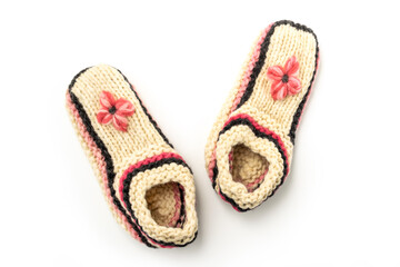 White knitted woolen slippers on a white background close-up.