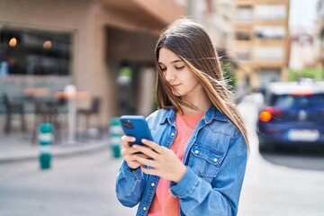 Adorable girl using smartphone at street