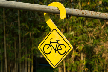 Yellow sign bicycle parking at park.