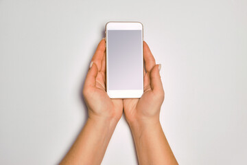 Female hands holding modern cellphone. Close up of woman hands holding smart phone with blank screen. Empty smartphone white screen ready for your app to be placed isolated on white background.