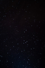 Natural organic dust particles floating on a sunbeam on black background. Glittering sparkling flickering in space 3D illustration. High Quality Vertical Photo