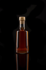 Bottle of wine vinegar isolated in front of a black background