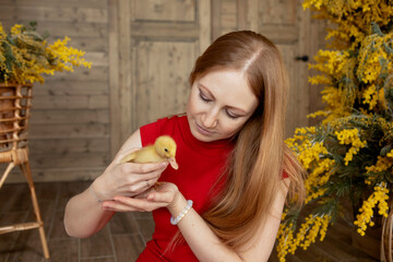 girl with long red hair in a red dress with a small yellow duck in her hands