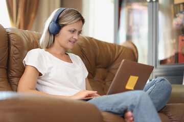 Obraz premium Young freelancer woman listens to music in headphones