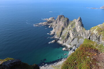 Fototapeta premium Steep cliff into the blue sea on the mountain hiking trail Måtind Andøy Northern Norway