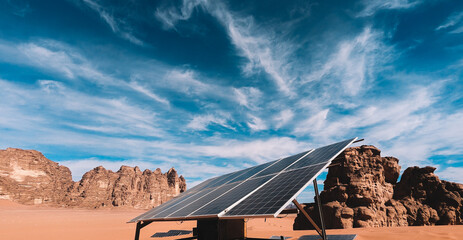 A solar panel sits in the desert with a mountain in the background.