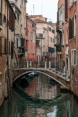 Fototapeta na wymiar Venice, view of a canal on a misty day, bridge over canal in the background.
