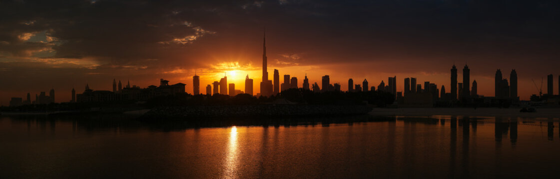 High resolution panoramic photo of Dubai skyline during a spectacular sunrise. View to skyscraper modern architecture buildings and Burj Khalifa tower.