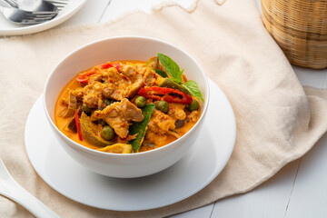 Thai curry red soup,Thailand tradition menu,boiled sliced pork with red curry paste and coconut milk in white bowl