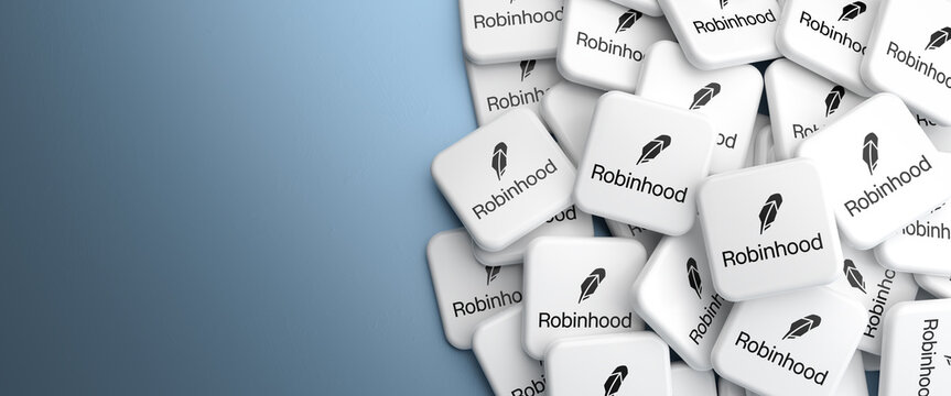 Logos of the neo broker Robinhood on a heap on a table. Web banner format, copy space