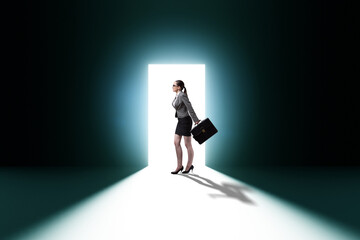 Businesswoman entering backlit door in escape concept