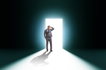 Obraz premium Businessman entering backlit door in escape concept