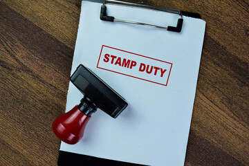 Concept of Red Handle Rubber Stamper and Stamp Duty text isolated on on Wooden Table.