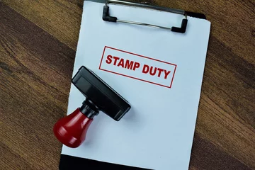 Foto op Canvas Concept of Red Handle Rubber Stamper and Stamp Duty text isolated on on Wooden Table. © syahrir