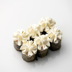 Set of sushi rolls decorated with cream cheese from pastry bag. Futomaki rolls. Japanese, Asian cuisine. Seafood dishes. White background. Top view. Copy space.