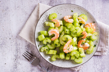 Closeup of fresh salad of celery and shrimp on a plate for a vegetarian diet top view