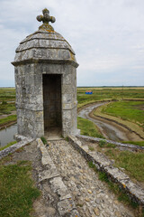 Fototapeta na wymiar closeup of an old stone lookout with a view on the salty marsh and the river from the village of Hiers-Brouage, Vendée, France