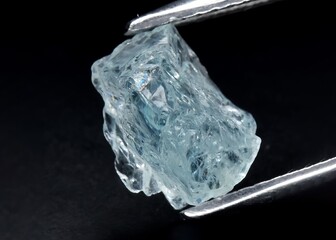 Natural blue aquamarine gemstone on gray background