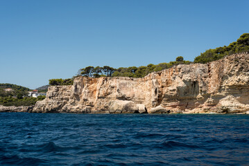 Fototapeta na wymiar Mediterraner Sommer Küstenlinie bei Bootstour vom Meer mit idyllische Küstenlandschaft in Griechenland