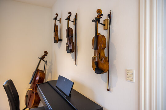 A photo of musical instrument: violins, chello or piano in a music room.