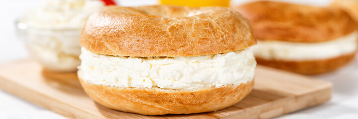 Bagel sandwich with cream cheese for breakfast close up panorama