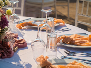 Table at luxury wedding reception event. Beautiful flowers on table and serving dishes and glasses and decoration